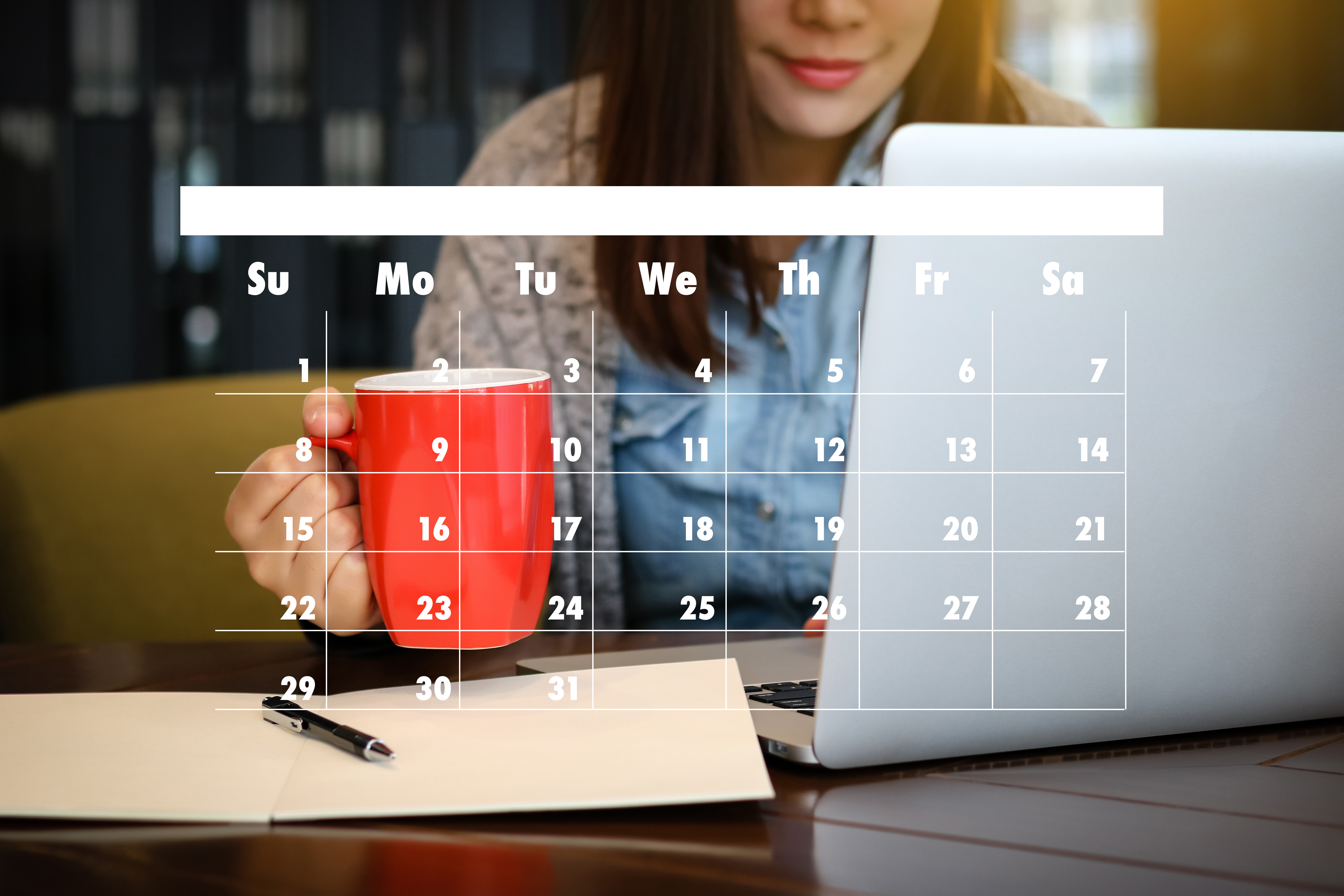 Woman working on a laptop holding a red mug and with a calendar over on the image